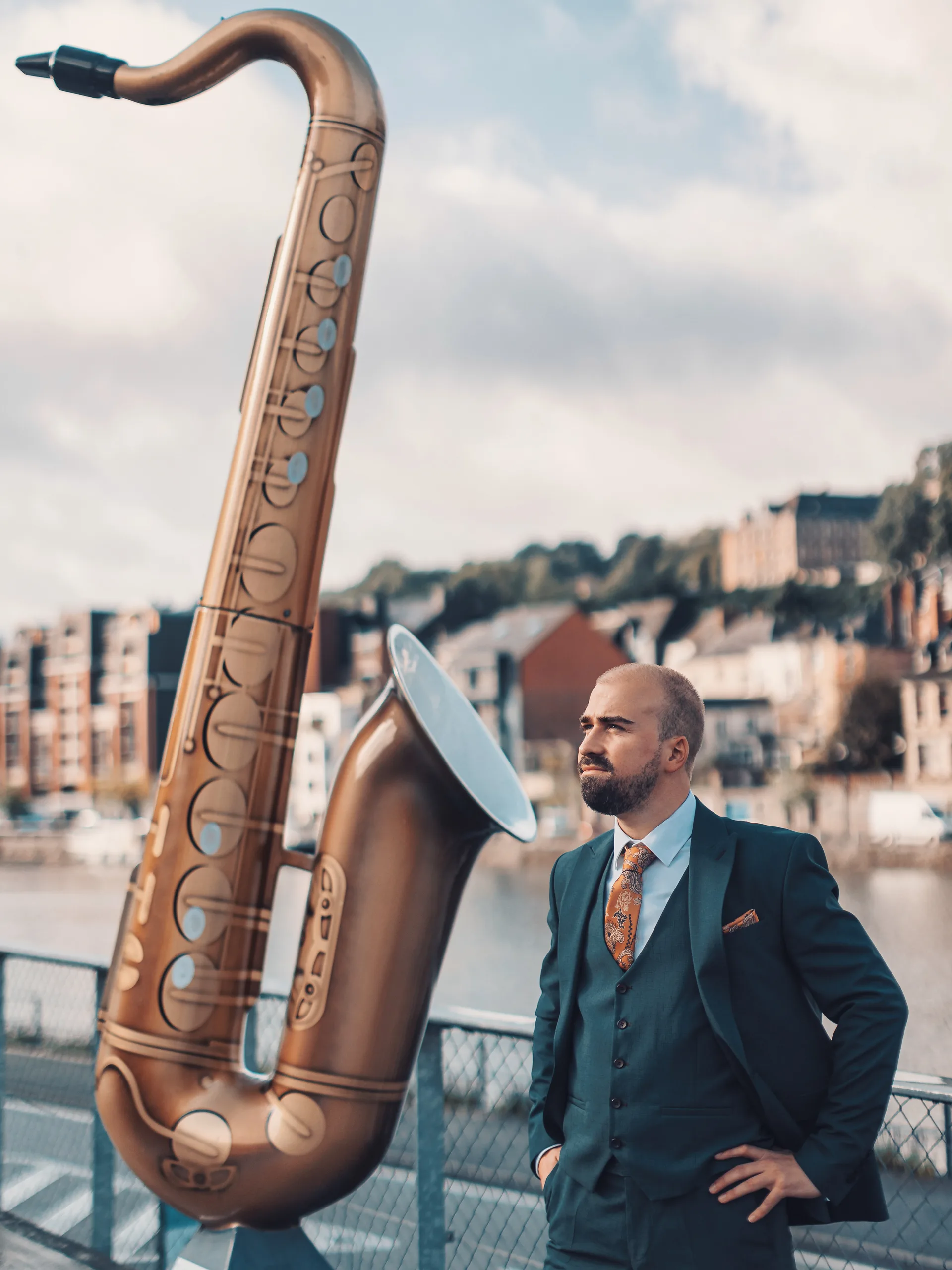 Le marié pose près de la statue du saxophone à Dinant, avant la cérémonie civile