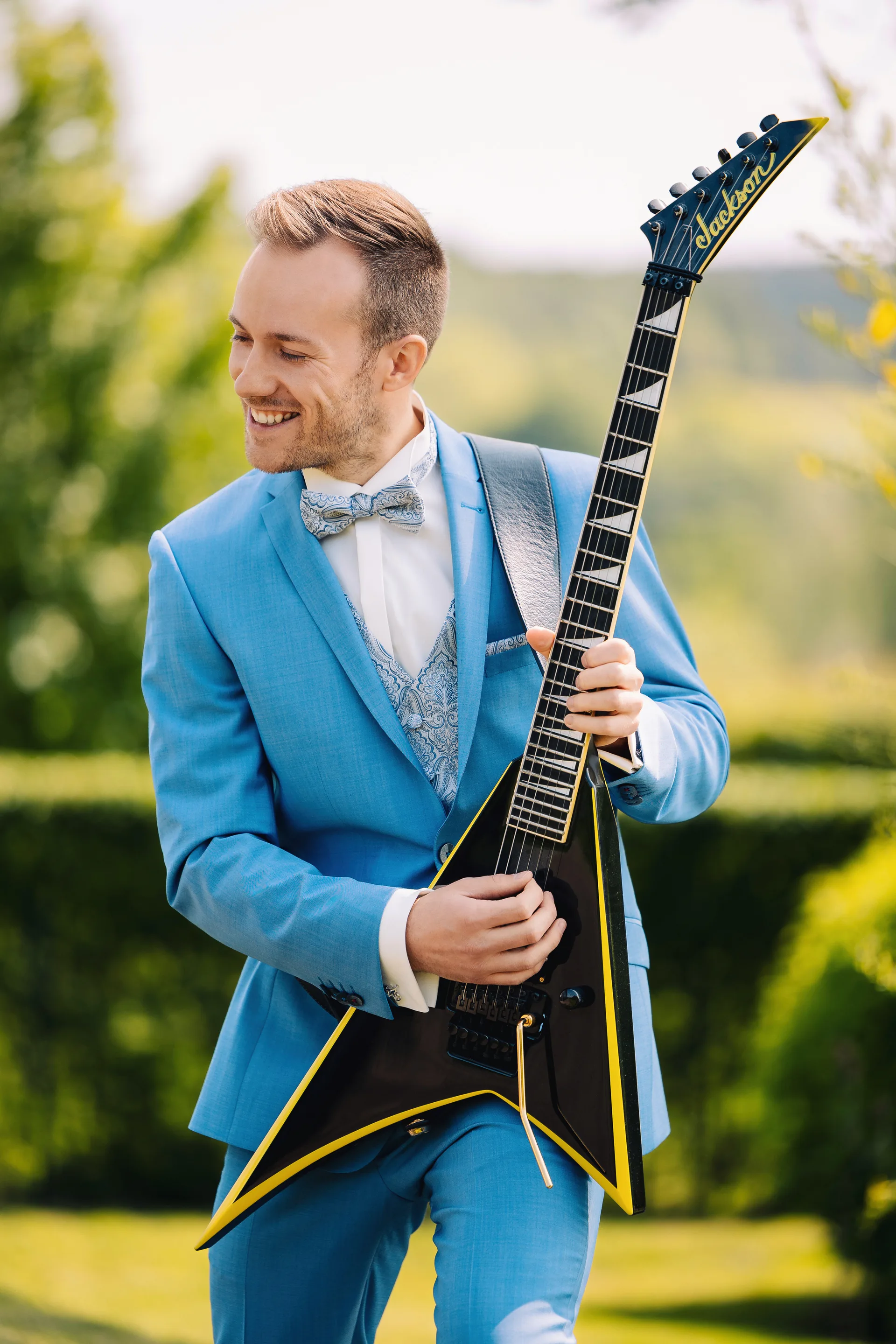 Le marié joue de la guitare électrique, moment complice avant la cérémonie
