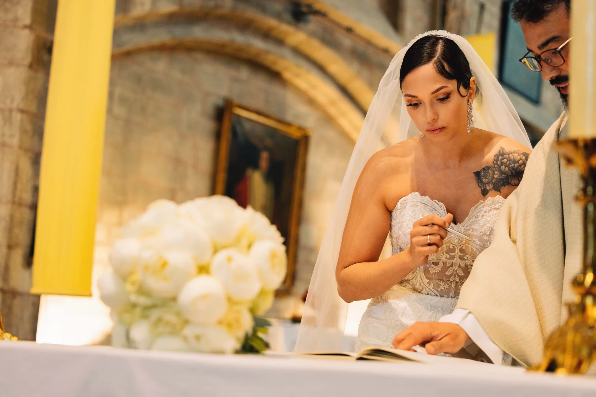 La mariée signe le registre pendant la cérémonie religieuse